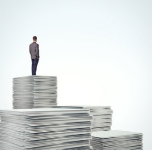 businessman standing on a pile of blank documents