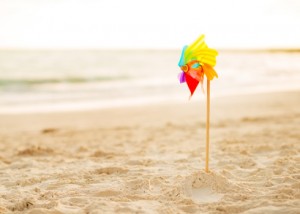 сolorful windmill toy standing on the beach in the evening