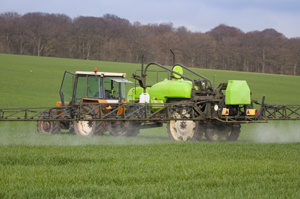 Tracteur pulvérisant du désherbant sur un champ de blé