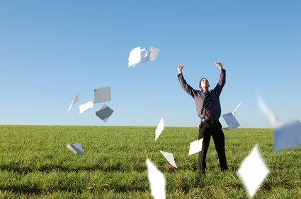 A happy businessman letting go of paperwork