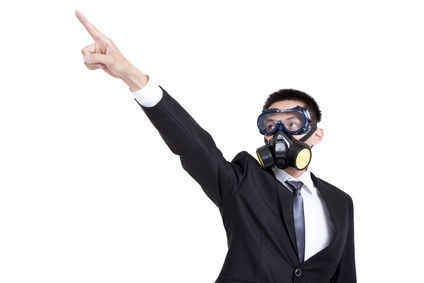 Young businessman with gas mask pointing afar