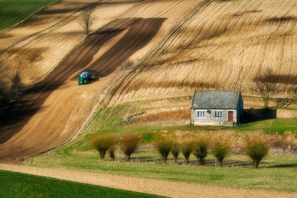 Farmer in tractor preparing land with seedbed cultivator, spirng, countryside in Ponidzie, Poland