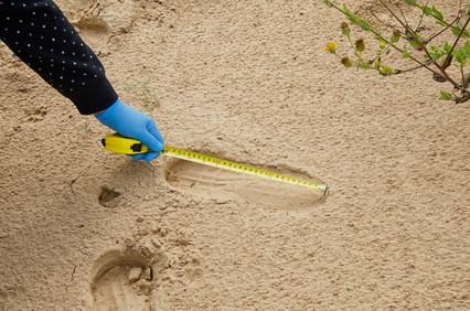 Expert measuring the shoe print length in the desert