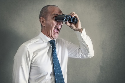 uomo in camicia e cravatta che gurda con il binocolo urlando