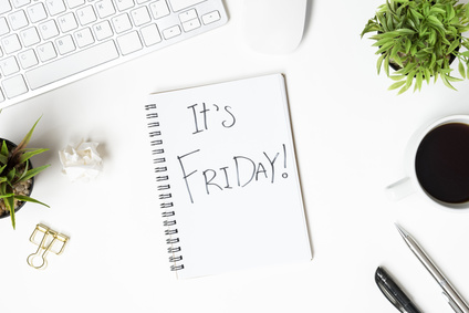 The notebook with Friday motivation text is on top of white office desk table. Top view, flat lay.